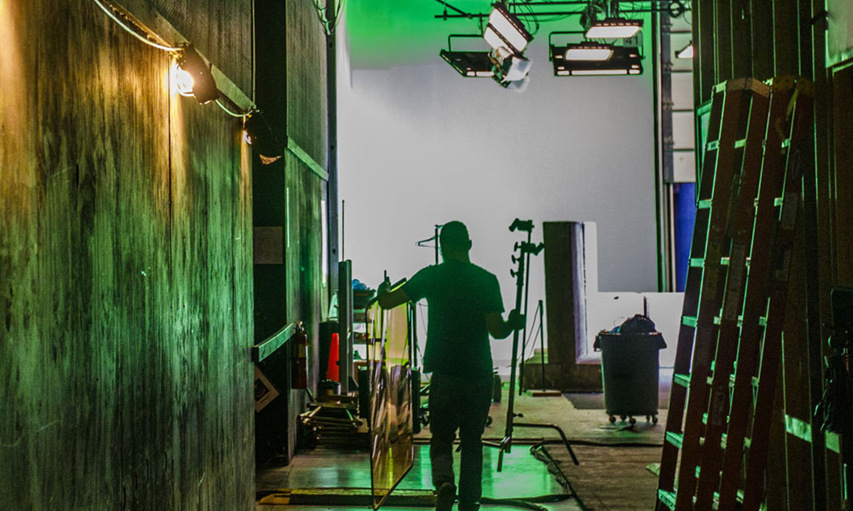 person carrying stage gear on set