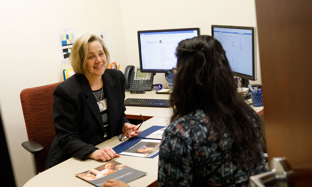 Admission officer with a graduate student in an office