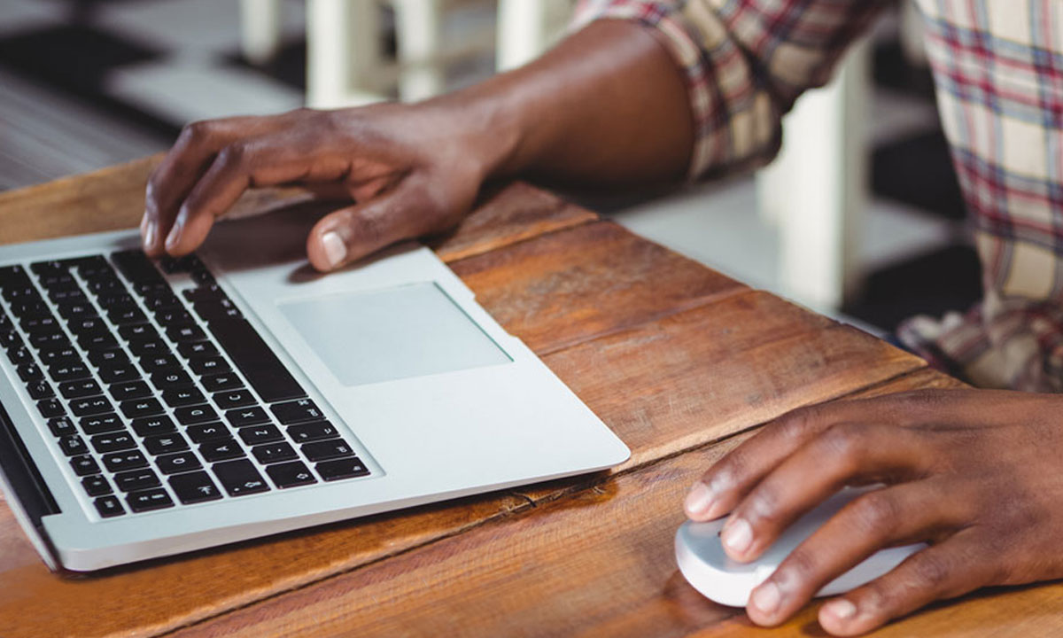 male working on laptop at coffee shop