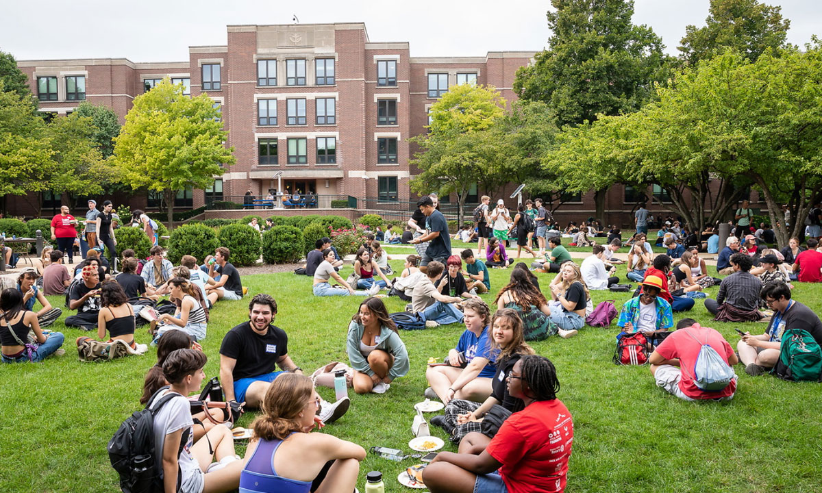 many students sitting on the grass